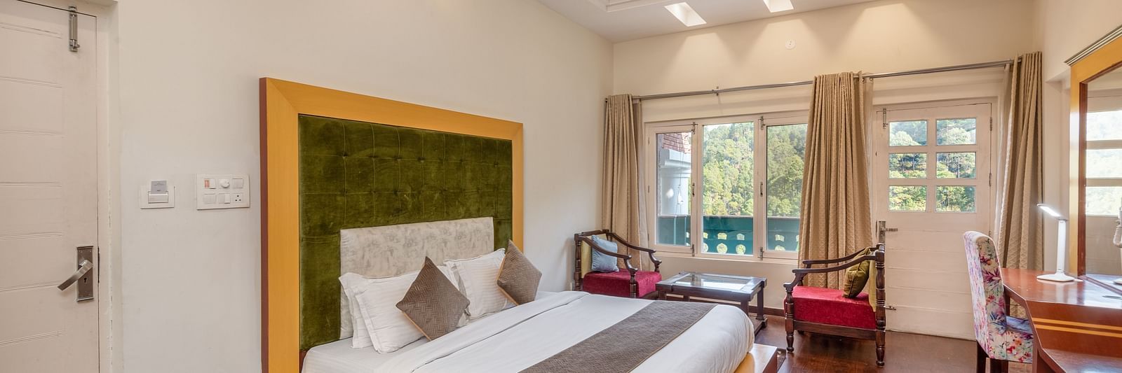 Comfortable and inviting room at DLS Tehri Club Resort with a warm colour scheme and hardwood floors.